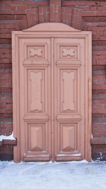 Фото Старая коричневая деревянная дверь на кирпичной стене
