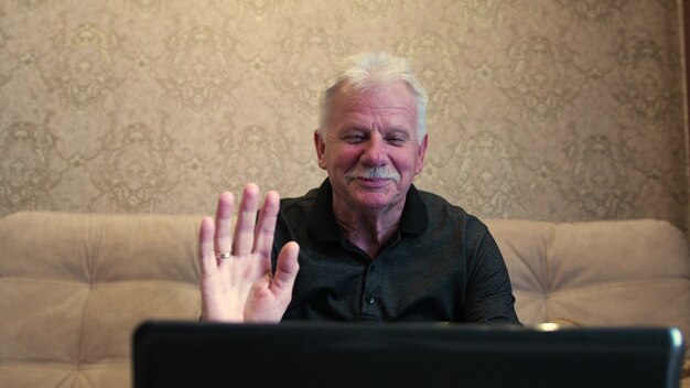 사진 검은 셔츠에 노인 노트북 카메라에 그의 손을 파도.