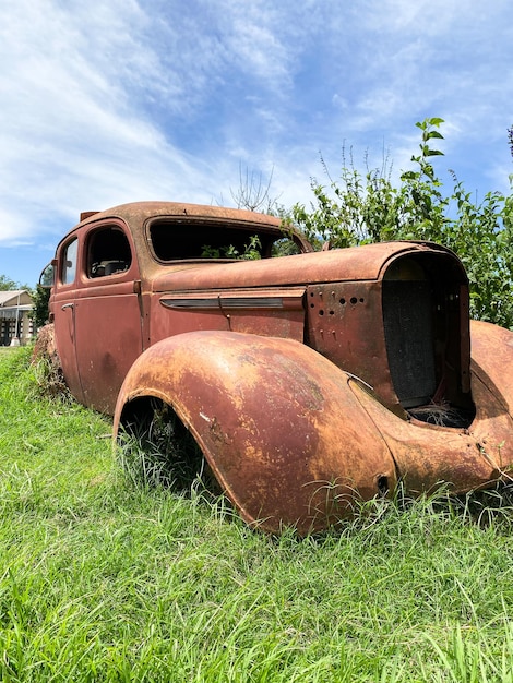 写真 古い生<unk>した車が草の上に座っている