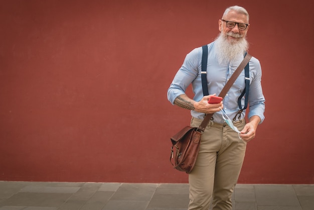 写真 流行に敏感な服と眼鏡をかけた年配の男性と長い白ひげが電話で話している