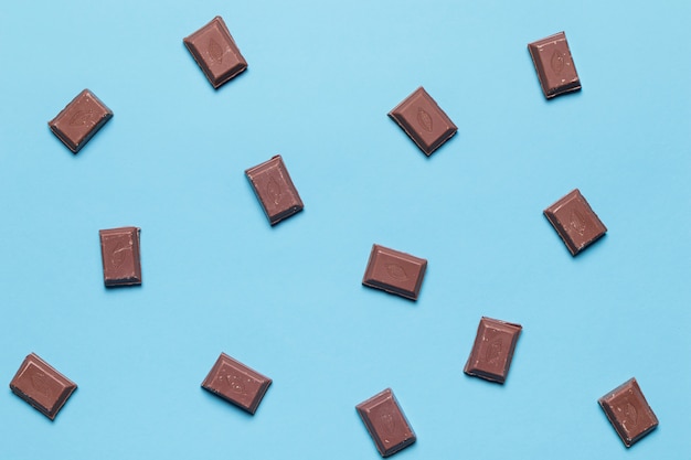 Вид сверху кусочками шоколада на синем фоне