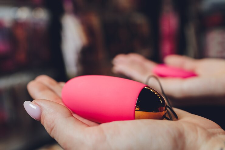 Foto anale plug met een donzige roze staart met vrouwelijke handen. speelgoed voor spelletjes voor volwassenen.