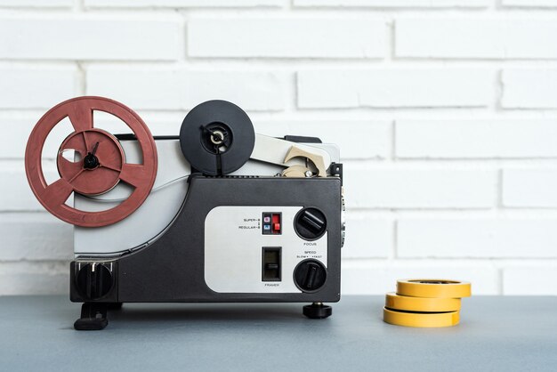 Analog audio device and tapes placed on table near white brick\
wall at home