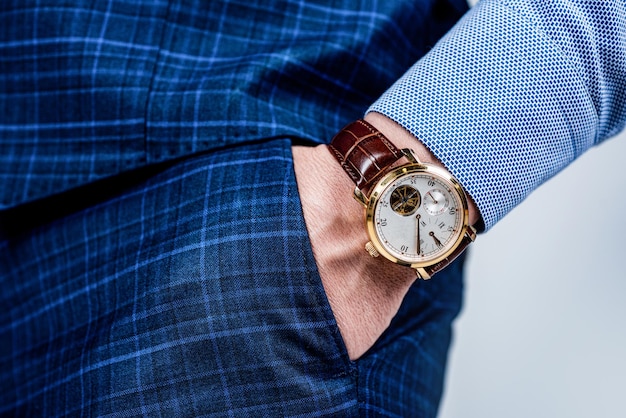Orologio da polso analogico indossato sul braccio maschile nella tasca dei pantaloni, orologio da polso.