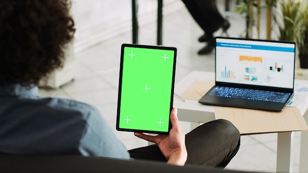 Аналитик держит устройство с зеленым экраном, просматривая годовую статистику и цветной дисплей, малый бизнес. Предприниматель, работающий с изолированным экраном шаблона, отчет табло.