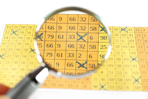 Analyzing lottery ticket with magnifier closeup