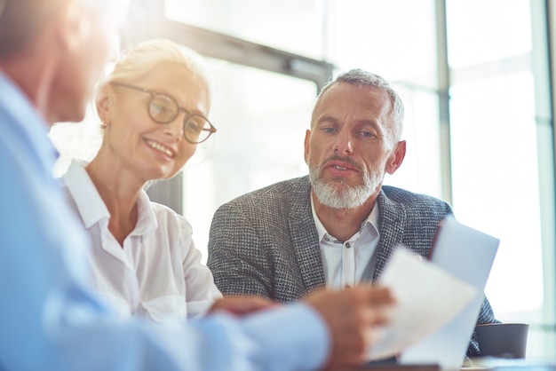 Analyzing report successful business people working together sitting at desk in the modern office