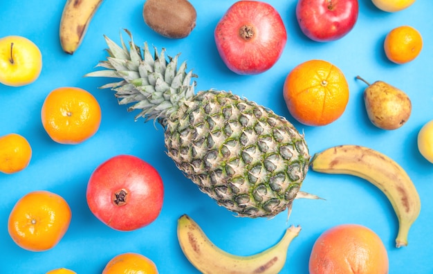 Ananas, banaan, granaatappel op een blauwe achtergrond.