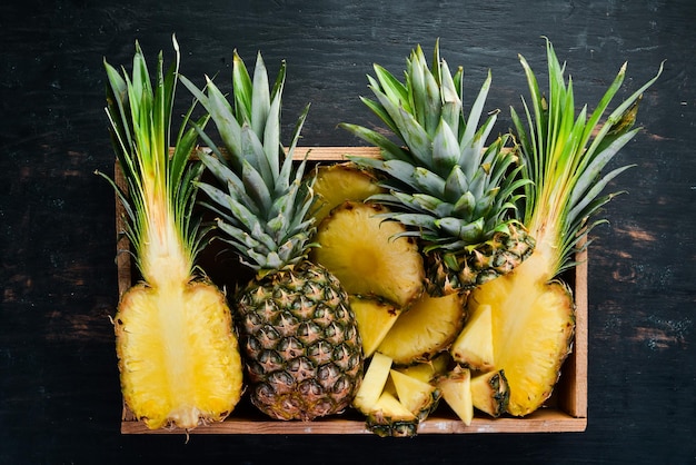 Ananas in een houten kist Tropisch fruit Bovenaanzicht Gratis kopieerruimte