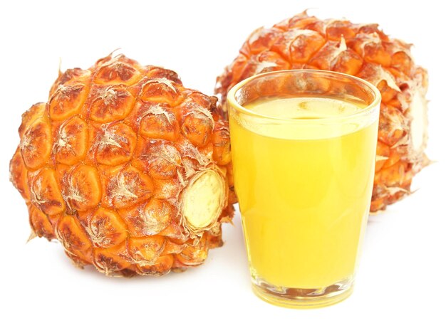 Ananas met sap in een glas op witte achtergrond