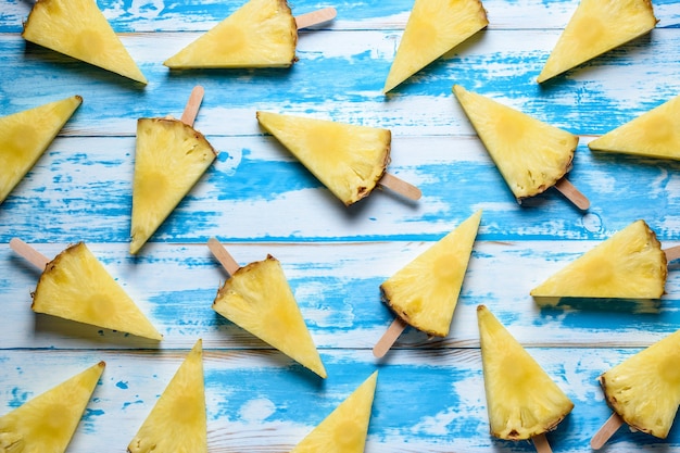 ananas op ijsstokjes op houten ondergrond