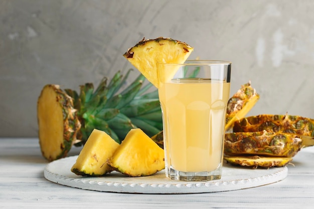 Ananas vers sap in glas op een houten tafel