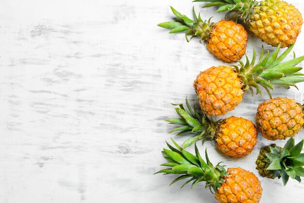 Ananas witte achtergrond Rijpe baby ananas op een witte houten achtergrond Tropisch fruit Bovenaanzicht Vrije ruimte voor tekst