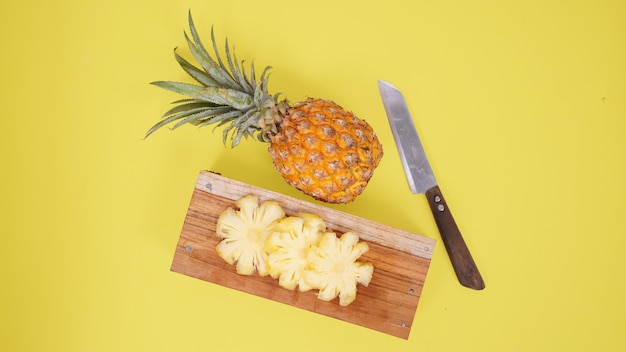 Ananasfruit en sommige stukjes geïsoleerd op een gele achtergrond