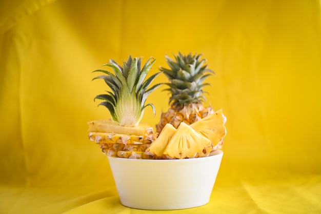Ananasplak op plaat voor voedselfruit rijpe ananas op gele achtergrond verse ananas tropisch fruit zomer