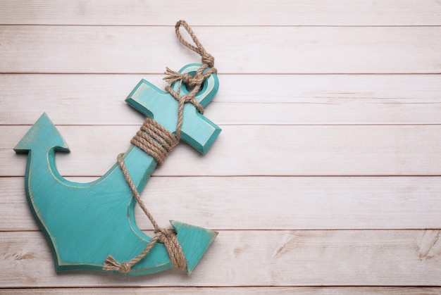 Anchor with hemp rope on wooden table top view Space for text