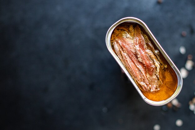 Photo anchovies canned in a tin can on the table