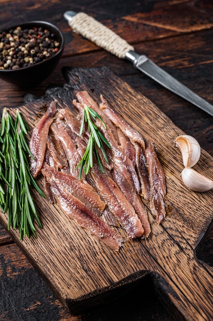 Anchovies pickled fish fillet on a wooden board