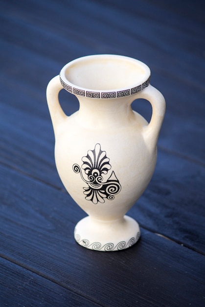 Photo ancient amphora (jug) on a black wooden background