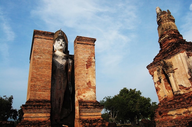 Antica architettura dell'antichità e antiche rovine di edifici per i viaggiatori thailandesi che viaggiano visitano il rispetto pregando al parco storico di si satchanalai e patrimonio mondiale dell'unesco a sukhothai thailandia