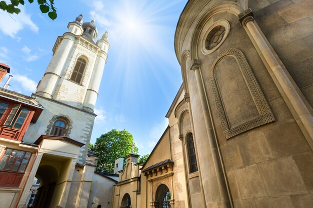 Lviv City (우크라이나)의 고대 아르메니아 교회와 푸른 여름 하늘의 햇빛