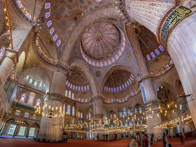 Photo ancient blue mosque or sultanahmet mosque sumptuous interior view with tourists istanbul turkiye