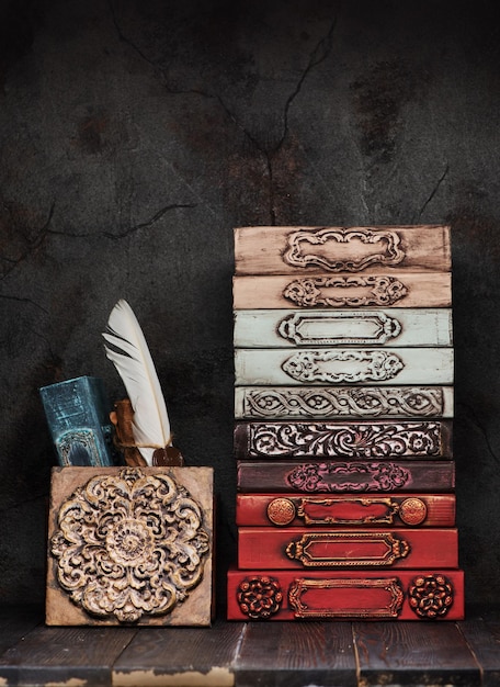 Ancient books, manuscripts and an antique inkwell on a shelf and stucco decor of gypsum plaster