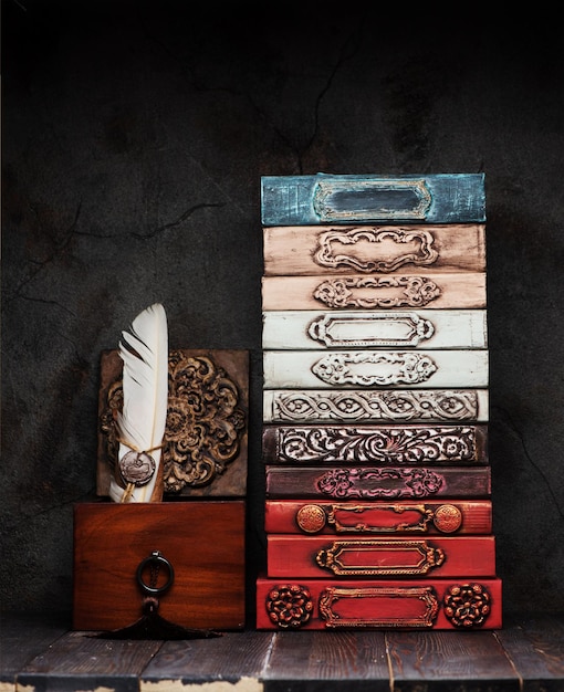 Photo ancient books, manuscripts with wax seal on a shelf and stucco plaster tiles with medallion