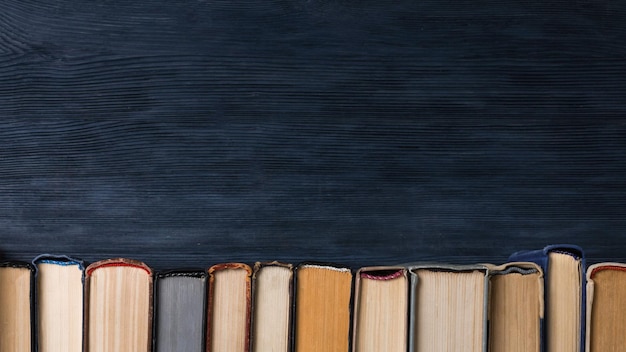 Photo ancient books in row on dark background