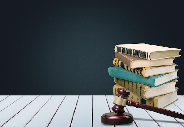 ancient books in row and hammer on wooden table