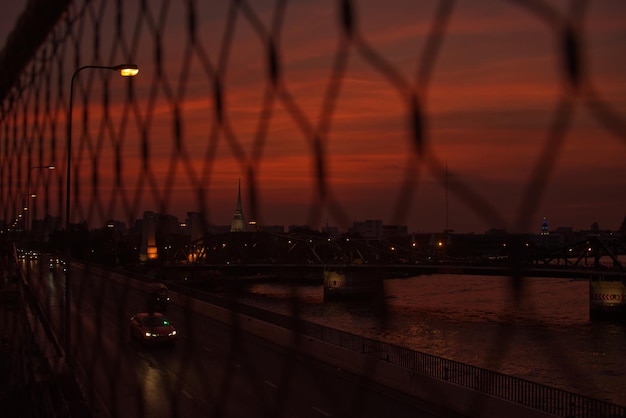 Ancient bridge and modern bridge  with blur net fence foreground a sunset time