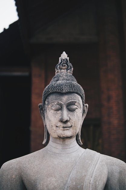 Ancient Buddha statues placed on brick walls in Thai temples