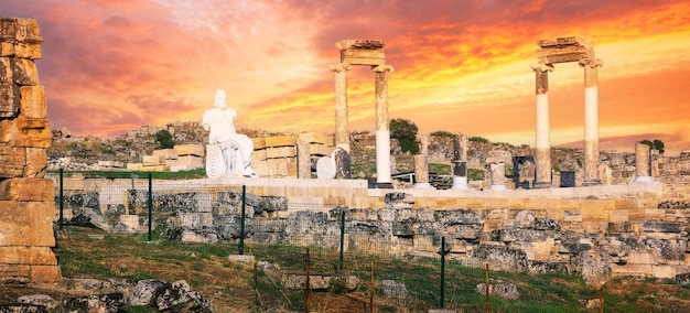 Antica città di hierapolis con la statua di plutone a pamukkale sotto il cielo drammatico