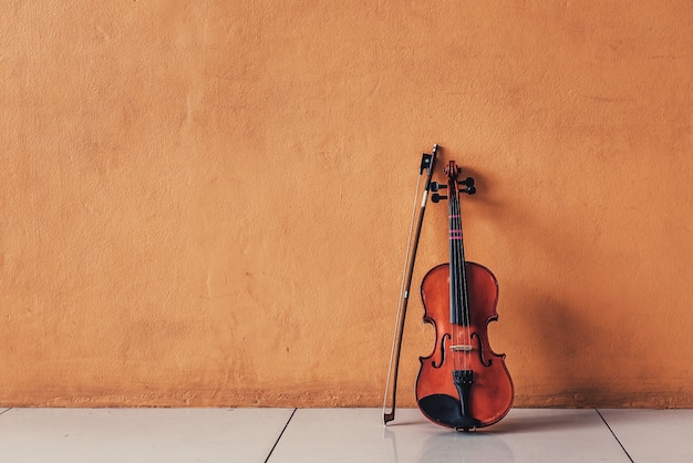 Ancient Classical Violin Lay on Orange Cement Walls