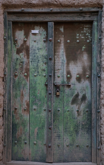 Ancient door carved with engravings of an ancient mud house in Oman