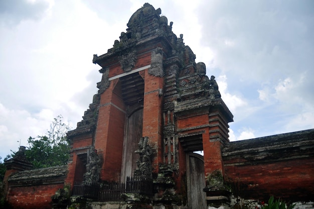 Древний вход во внутреннее святилище храма Пура Таман Аюн или Менгви, важное индуистское археологическое место для путешественников, люди путешествуют, посещают и уважают, молятся в Регентстве Бадунг на Бали, Индонезия