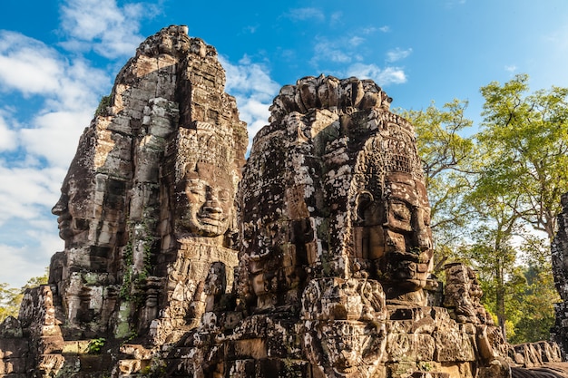 Ancient face of Bayon castle on blue sky.