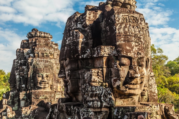 Ancient face of Bayon castle on blue sky.