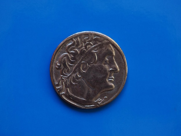 Ancient greek coin over blue