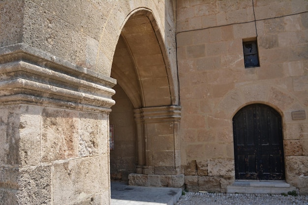 アーチ型のレンガの壁と金属製のドアのある古代ギリシャの通り