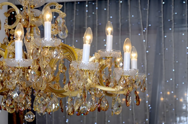 An ancient hanging retro chandelier with built-in lamps for electric lighting
