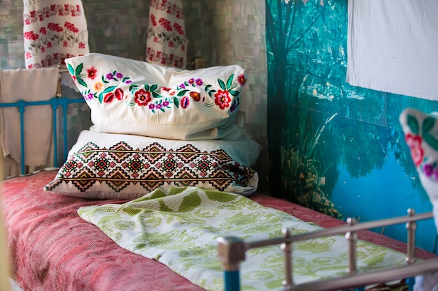 An ancient iron bed with embroidered cushions