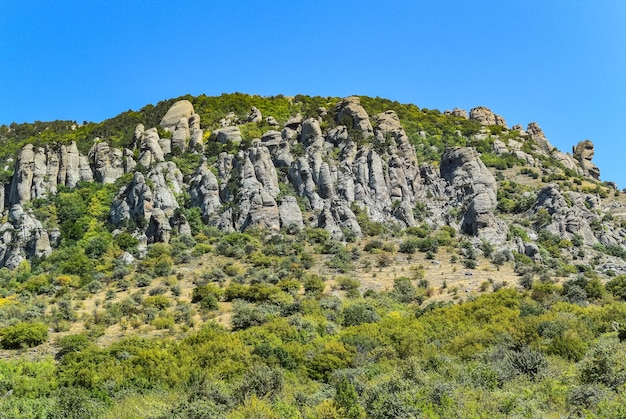 Ancient limestone high mountains of rounded shape in the air haze The Valley of Ghosts Demerji