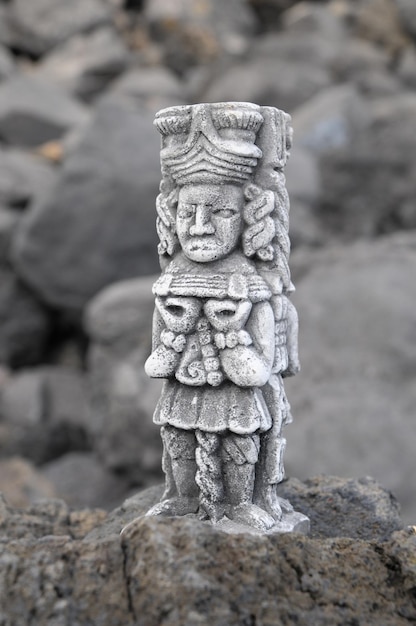 Древняя статуя майя на скалах у океана