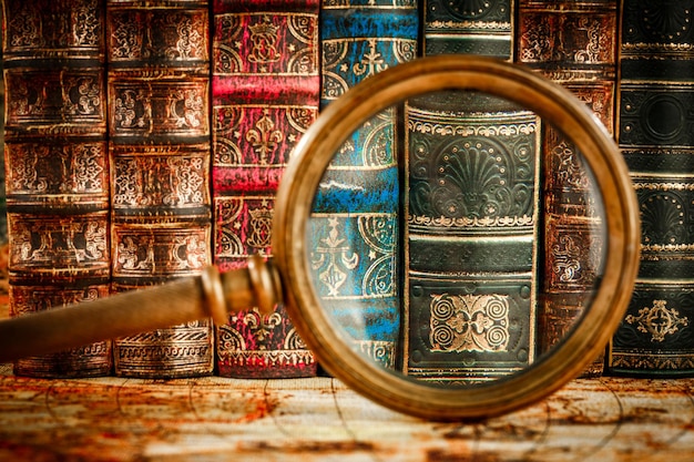 Photo ancient old books and magnifying glass