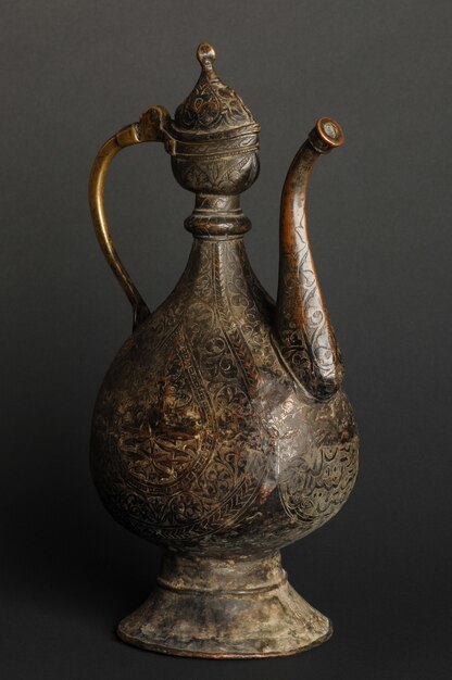 Ancient oriental metal teapot on dark background. antique bronze tableware