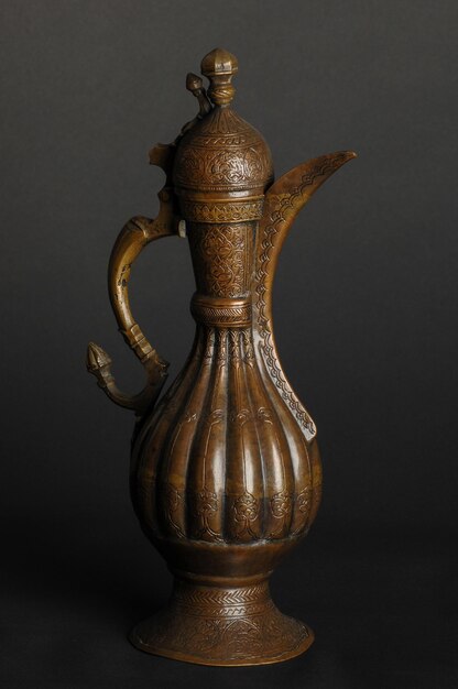 Ancient oriental metal teapot on dark background antique bronze tableware