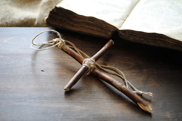 Ancient religious book and wooden cross on the background of a wooden and burlap