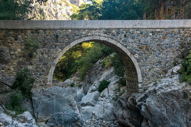 Foto antico ponte romano su una ombrosa gola di montagna nel canyon di kesme bogazi, turchia