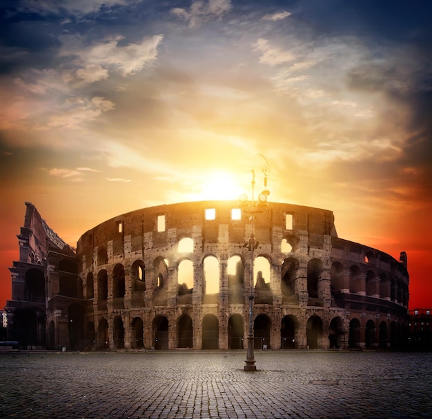 Ancient roman colosseum and sunny sunrise in Rome, Italy